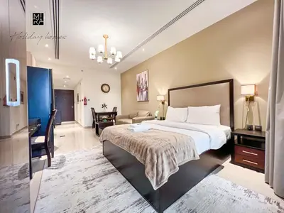 a hotel room with a bed and a living room at Mira Holiday Homes - Newly furnished studio in Downtown in Dubai