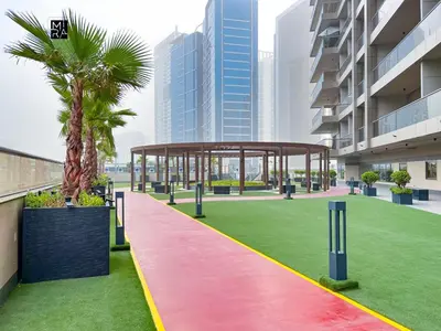 a pavilion with a palm tree on a green lawn at Mira Holiday Homes - Newly furnished studio in Downtown in Dubai