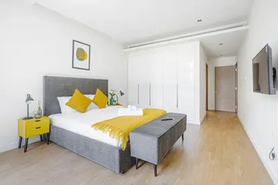 a bedroom with a large bed with yellow pillows at Vonder: City Walk in Dubai