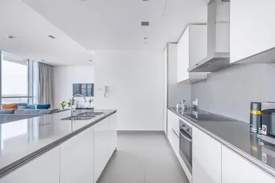 a white kitchen with a sink and a stove at Vonder: City Walk in Dubai