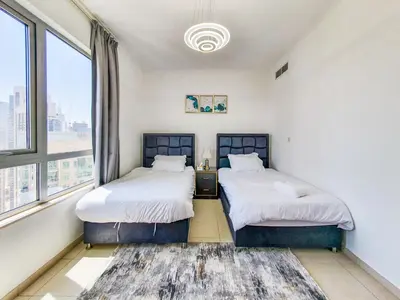 two beds in a room with a large window at The Residence 7 Downtown - Full Burj Khalifa and Fountain Views by Gardenia Suites in Dubai