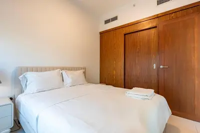 a bedroom with a bed with a wooden door at Splendid 3BR Apartments - Burj Khalifa & Fountain Views - 5 Minutes Walk from Dubai Mall in Dubai