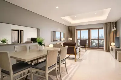 a dining room and living room with a table and chairs at Wyndham Residences The Palm in Dubai