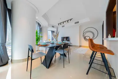 a dining room with a black table and chairs at EDEN'S Homes & Villas - Opera Grand in Dubai