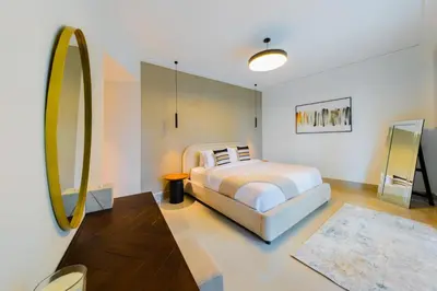a bedroom with a bed and a large mirror at EDEN'S Homes & Villas - Opera Grand in Dubai
