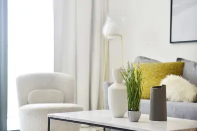 a living room with a couch and a table with vases at The Smart Concierge - Beach Vista 2 in Dubai