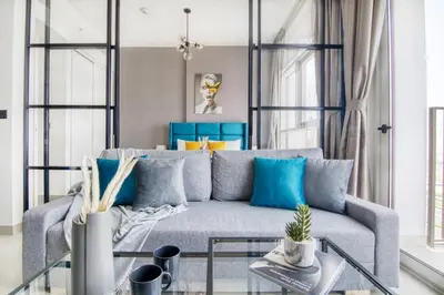 a living room with a gray couch and blue pillows at GuestReady - In the Heart of Dubai Hills in Dubai