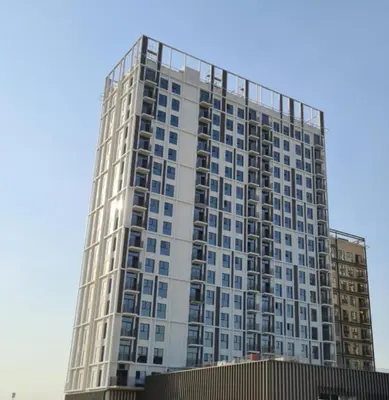 a tall white building with many windows at GuestReady - In the Heart of Dubai Hills in Dubai