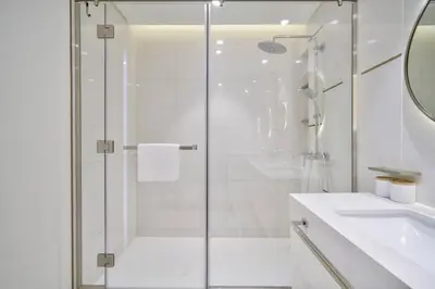 a white bathroom with a shower and a sink at Beach Vista 1 Emaar Beachfront - Mint Stay in Dubai