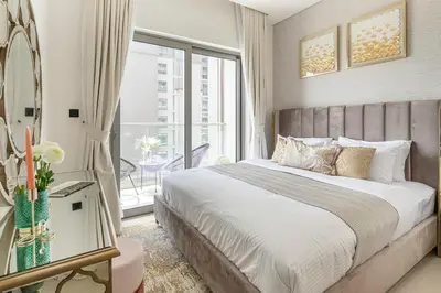 a bedroom with a large bed and a balcony at Frank Porter - Sobha Creek Tower B in Dubai