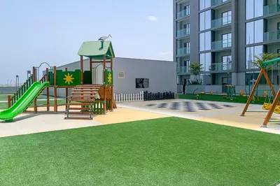 an empty playground with a slide and a swing at Frank Porter - Sobha Creek Tower B in Dubai