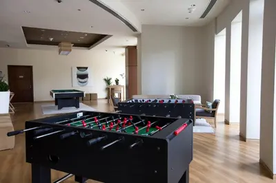 a living room with a large foosball table at Luxury 2BR Sea & Skyline Views Near Metro & Burj Khalifa in Dubai