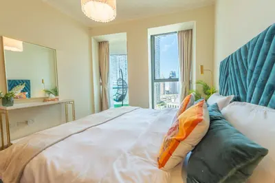 a bedroom with a bed with pillows and a window at Luxury 2BR Sea & Skyline Views Near Metro & Burj Khalifa in Dubai