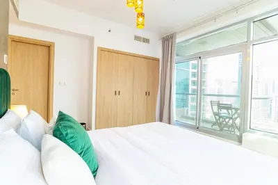 a bedroom with a white bed and a large window at Luxury Escapes - Full Marina View Luxury 2BR - Park Island Sanibel in Dubai