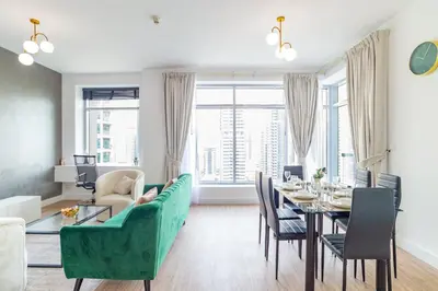a living room with a table and a green couch at Luxury Escapes - Full Marina View Luxury 2BR - Park Island Sanibel in Dubai