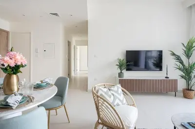 a living room with a table and chairs and a tv at Frank Porter - Park Ridge C in Dubai