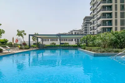 a large blue swimming pool in front of a building at Frank Porter - Park Ridge C in Dubai