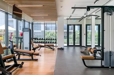 a gym with several treadmills and pilates equipment at Frank Porter - Park Ridge C in Dubai