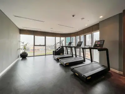 a row of treadmills in a gym with windows at Luton Vacation Homes - Damac Paramount Midtown Business Bay Dubai - 37AB09 in Dubai