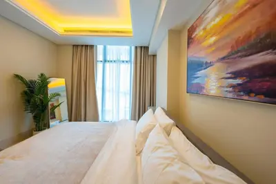 a bedroom with a bed with a painting on the wall at Spacious beachfront 2 bedroom apartment - The 8 in Dubai