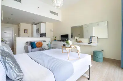 a bedroom with a white bed and a living room at Frank Porter - Marina Views B in Dubai