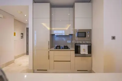 a kitchen with white cabinets and a stove top oven at Cozy beachfront 1 bedroom apartment - The 8 in Dubai