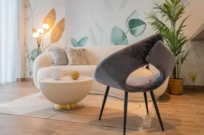 a living room with a chair and a couch at Desert Living Luxury Condo - Jumeirah Living Marina Gate in Dubai