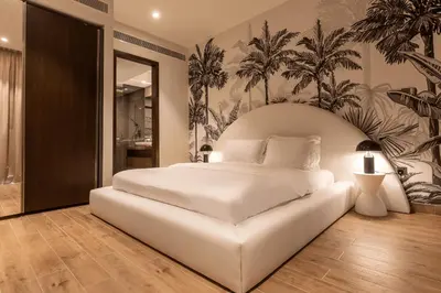 a bedroom with a large white bed with a tropical wallpaper at Desert Living Luxury Condo - Jumeirah Living Marina Gate in Dubai
