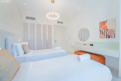 a white room with two beds and a couch at JBR Amwaj 4 , Upgraded Sea and Ain Dubai Views, 2m walk to Beach By Gardenia Suitse in Dubai