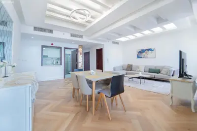 a living room with a table and a couch at JBR Amwaj 4 , Upgraded Sea and Ain Dubai Views, 2m walk to Beach By Gardenia Suitse in Dubai