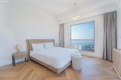a bedroom with a white bed and a large window at JBR Amwaj 4 , Upgraded Sea and Ain Dubai Views, 2m walk to Beach By Gardenia Suitse in Dubai