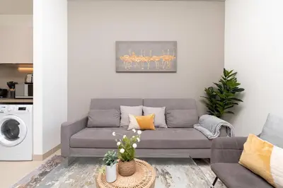 a living room with a couch and a table at White Sage - Elegant Apartment With Unobstructed City Views in Dubai