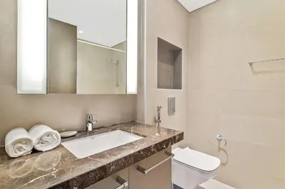 a bathroom with a sink and a toilet and a mirror at Silkhaus modern Boulevard 1BDR near Burj Khalifa in Downtown in Dubai
