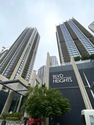 two tall buildings in a city with a sign forbid heights at Silkhaus modern Boulevard 1BDR near Burj Khalifa in Downtown in Dubai