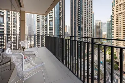 a balcony with two chairs and a table and some buildings at Frank Porter - Boulevard Crescent in Dubai