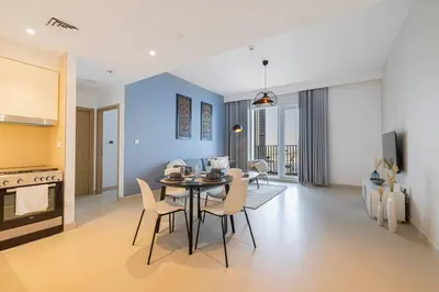 a kitchen and dining room with a table and chairs at Daniels 1BR at Creek Horizon with Park View in Dubai