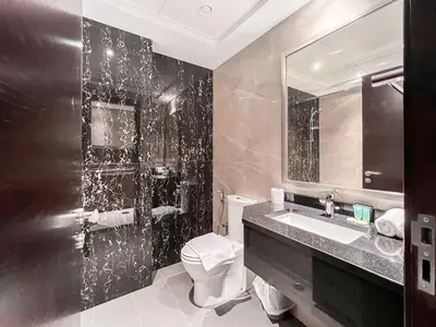 a bathroom with a toilet and a sink and a mirror at Luton Vacation Homes - Elite Residence Downtown, Dubai in Dubai