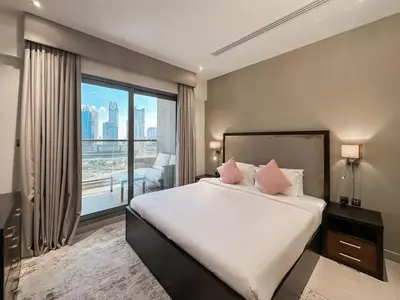 a bedroom with a large bed and a large window at Luton Vacation Homes - Elite Residence Downtown, Dubai in Dubai
