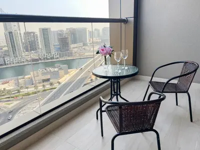 a table and two chairs in a room with a window at Luton Vacation Homes - Elite Residence Downtown, Dubai in Dubai