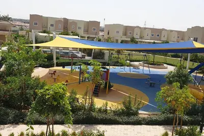 a playground with a blue and yellow canopy in a park at Elite Inn: Amaranta75 (Townhouse Direct pool view) in Dubai