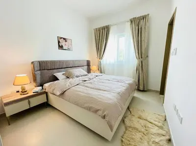 a bedroom with a bed and a table and a window at Elite Inn: Amaranta75 (Townhouse Direct pool view) in Dubai