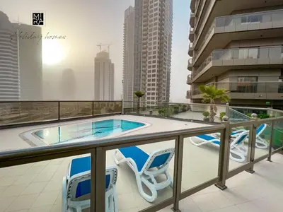 a balcony with a swimming pool and two chairs at Mira Holiday Homes - Furnished studio in Downtown in Dubai