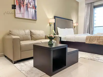 a living room with a couch and a bed at Mira Holiday Homes - Furnished studio in Downtown in Dubai