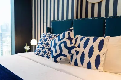 a bedroom with a bed with blue and white pillows at Ultimate Stay / 4 Beds / Burj Khalifa View / Ultra Modern / Business Bay in Dubai