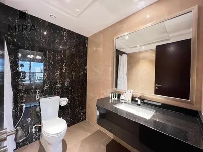 a bathroom with a toilet and a sink and a mirror at Mira Holiday Homes - Lovely 1 bedroom apartment in Downtown in Dubai