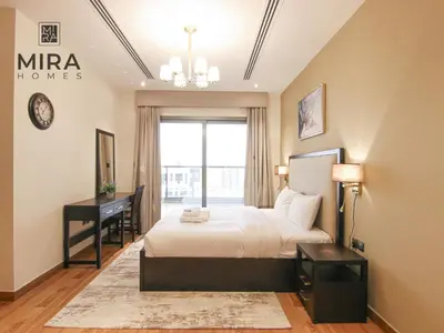 a bedroom with a bed and a desk and a window at Mira Holiday Homes - Lovely 1 bedroom apartment in Downtown in Dubai