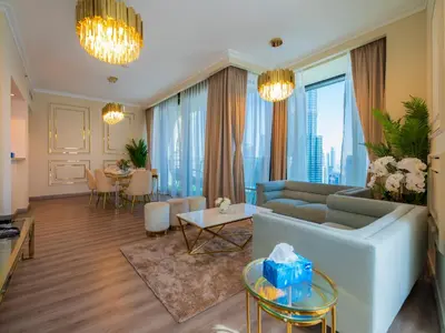 a living room with a couch and a table at Stylish 3BR Burj Khalifa, Fountain Views, Pool & Prime Location in Dubai