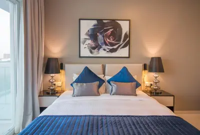 a bedroom with a large bed with blue pillows at Premium Studio with Beautiful Golf Course View in Dubai