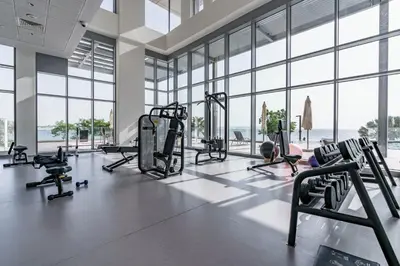 a gym with treadmills and machines in a room with windows at GuestReady - Stunning Apartment in Bluewaters in Dubai