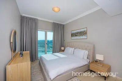 a bedroom with a bed and a large window at HomesGetaway -Fanciful 1BR Apartment in JLT Lake View in Dubai